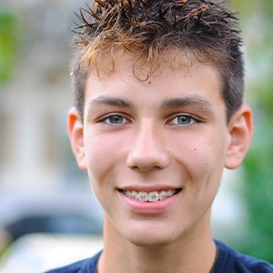 a teen with braces smiling
