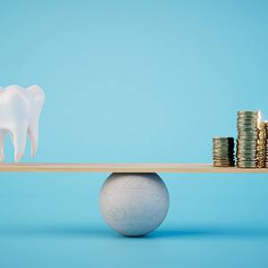 a stack of coins and a model tooth on a scale