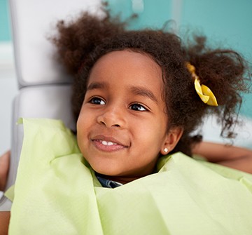 Smiling girl in dental chair for root canal treatment
