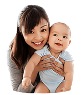 Mother holding smiling baby after receiving dentistry for infants