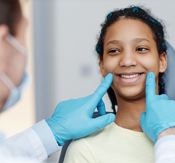 Dentist looking at teen's smile