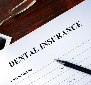 Dental insurance paperwork on desk with X-ray and glasses