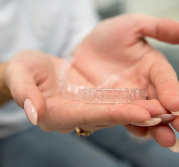 Closeup of patient holding clear aligner