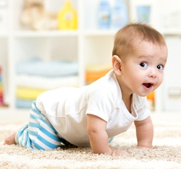 A baby crawling on its hands and knees after undergoing a laser frenectomy in Pelham