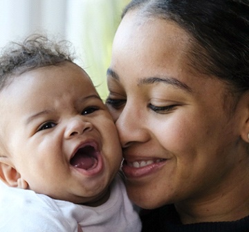 A mother and baby smiling after experiencing the benefits of a laser frenectomy