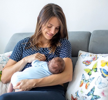 A mother breastfeeding her baby after laser frenectomy