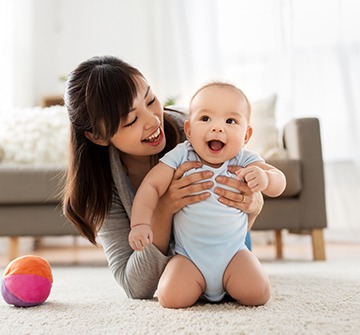 Mom and baby playing together on living room floor