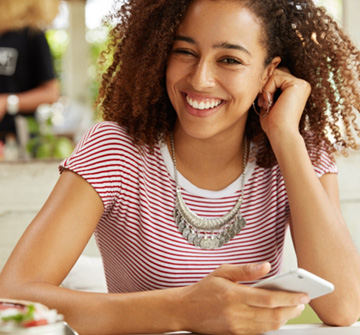 Teen smiling while sitting outside at restaurant