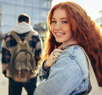 Teen smiling while walking on campus with friends