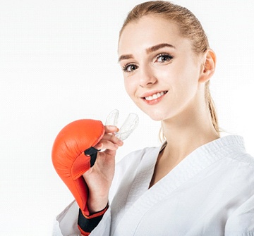 Girl with boxing gloves holds sports mouthguard in Pelham