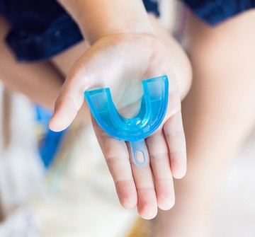 Closeup of dentist for children in Pelham holding sports mouthguard