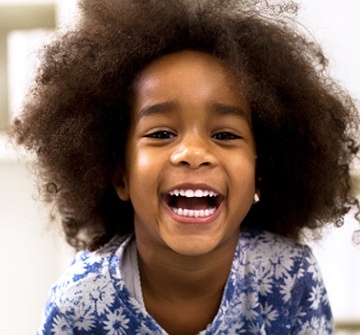 A young girl smiling after phase one orthodontics visit