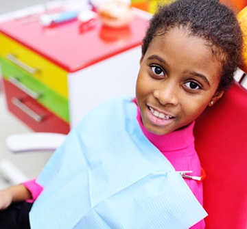 A young girl in the dental chair smiling after phase one orthodontics
