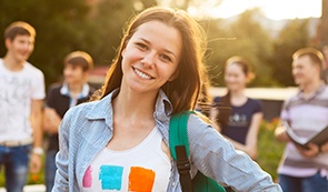 Teen girl smiling outdoors after dentistry for teens visit