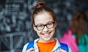 Smiling little girl with glasses after sedation dentistry visit