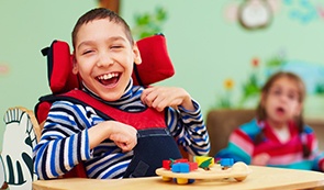 Laughing young boy in wheel chair after special needs dentistry visit