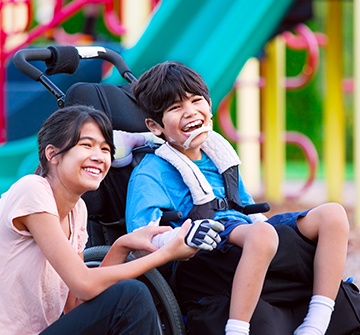 Two young people laughing together outdoors after special needs dentistry visit