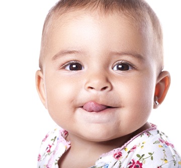 A teething baby with its tongue sticking out
