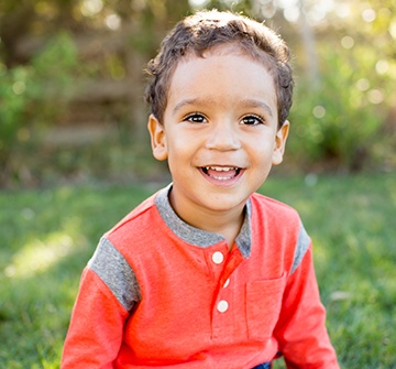 Toddler smiling outside after pulp therapy treatment