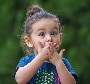 Toddler in need of emergency dentistry covering mouth