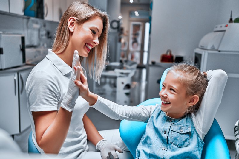 Pediatric dentist in Nashua high fiving a child