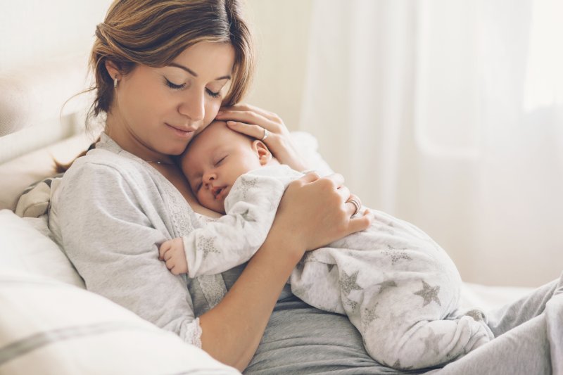 a mother holding her baby against her chest