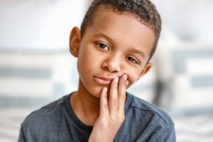 Young boy with toothache because of cavities