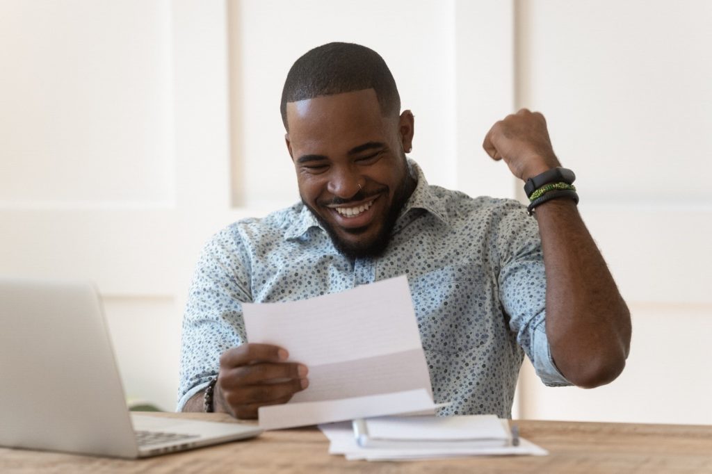 Man smiling while reviewing his tax refund information