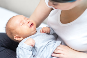 a parent comforting her crying baby 