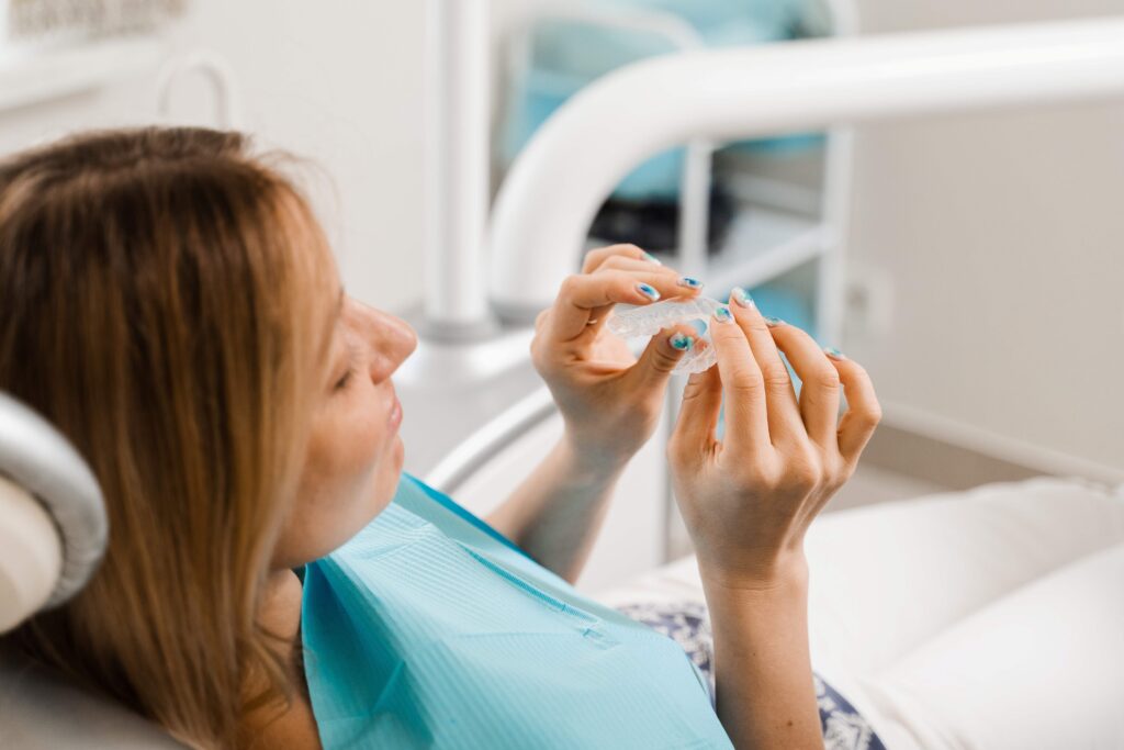 Patient holding clear aligner in treatment room