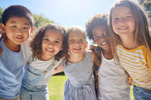 a group of kids smiling and playing outdoors